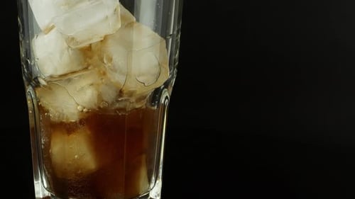 Soda Pours into Glass with Ice Cubes