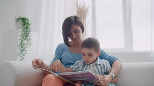 Mother and Child Reading a Book Indoors