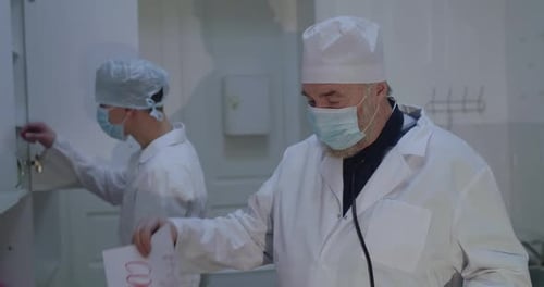Doctors with PPE in Hospital Holding a Sign