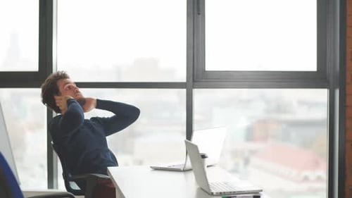 Bel entrepreneur barbu utilisant un ordinateur portable assis dans un espace de coworking