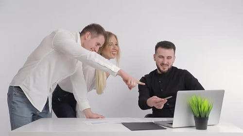 Business Partners, Along with Their Manager, View Information on the Computer and Smile. Happy