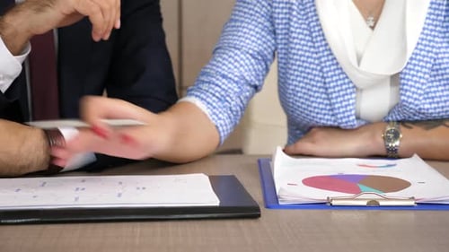 Geschäftsfrau im Gespräch mit seinem Kollegen und Analysieren von Diagrammen und Diagrammen mit dem Vertrieb