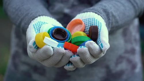 Hands in Work Handschuhe halten viele Plastikkappen