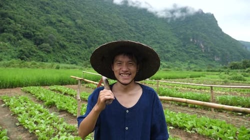Young Asian Farmer Smiling In Vegetable Garden