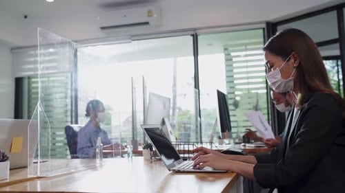 Asian young business woman working on computer in office with new normal lifestyle concept.