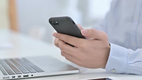 Close Up of Hand Using Smartphone at Work