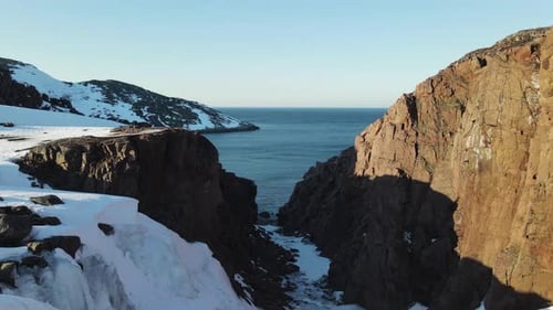 Winter Aerial Flight Top Over Waves Rolling on Artic Ocean Shore with Round Stones Ocean Waves at