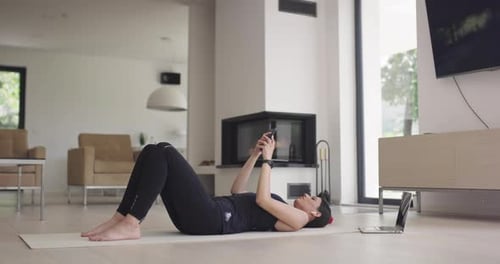Woman Lying on Mat Using Phone at Home