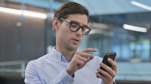 Porträt eines jungen Mannes mit Smartphone
