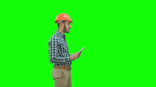 Contractor Engineer in Hardhat Inspecting Construction Site Holding Digital Tablet on a Green Screen