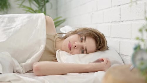 Woman Lying Awake in Bed Smiling