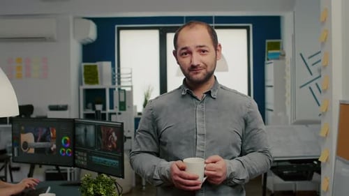 Man Holding Mug Smiling in Modern Office