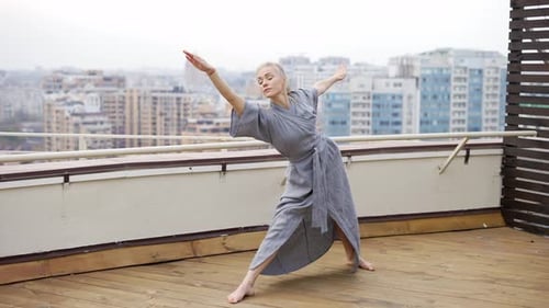 Yoga Coach in Robe at Terrace Doing Warrior Pose Virabhadrasana Triangle Pose Utthita Trikonasana