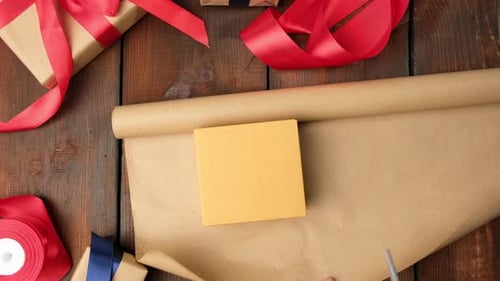 Hands Preparing Present on Wooden Table