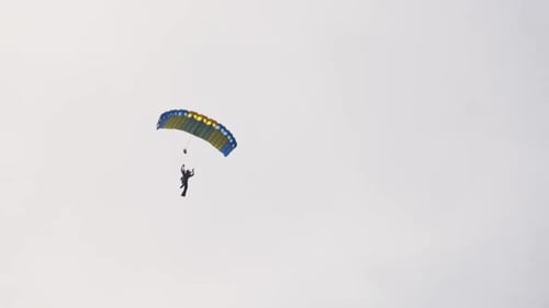 Parachuter Jumps From Sky on Sunny Day