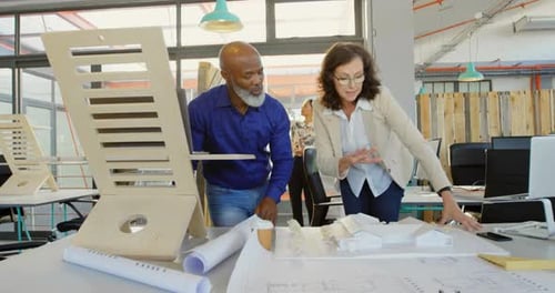 Architects Collaborating on Building Design in Modern Office