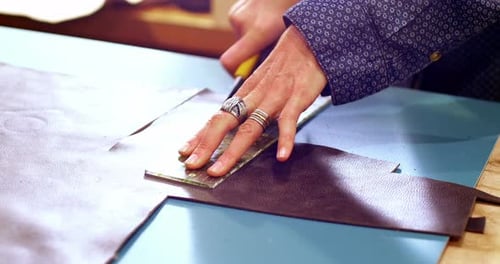 Person Cutting Leather With Blade and Ruler