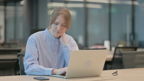 Young Woman Having Neck Pain While Using Laptop in Office