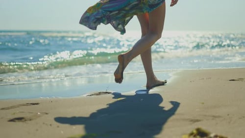 Female legs walking in wet sand