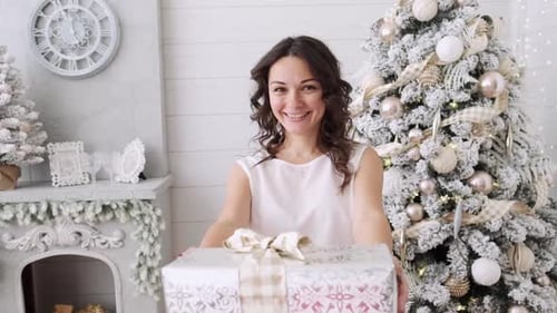 Woman Smiling with a Christmas Gift