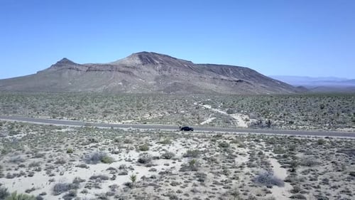 Einsames Auto steht auf der Straße, Berg. Spektakuläre Flugpanorama-Kurvenflugdrohne