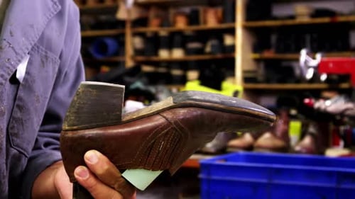 Shoemaker Hitting Shoe with Hammer in Workshop