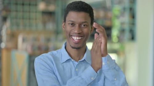 Wertschätzender junger afrikanischer Mann klatscht
