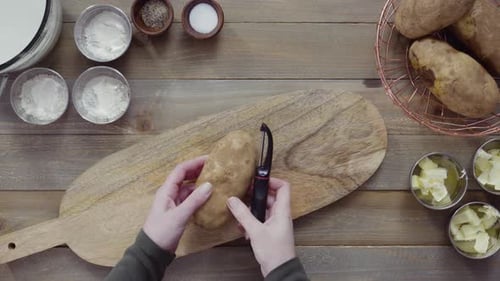 Flache Lage. Gelbe Bio-Kartoffeln mit Kartoffelschäler schälen
