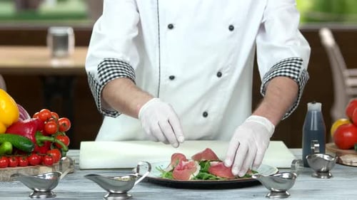 Chef Plates Prosciutto and Arugula in Restaurant