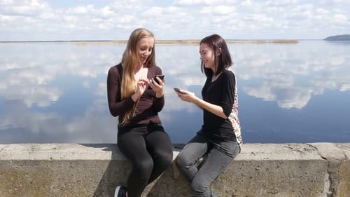 Girlfriends Are Sitting On The River Bank