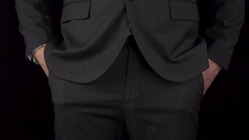 Un jeune homme d'affaires en costume sort un préservatif de sa poche et le tient dans sa main