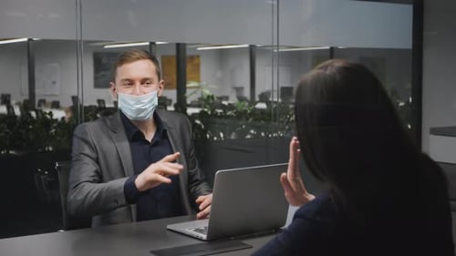 Man in Mask Discussing Work at Office