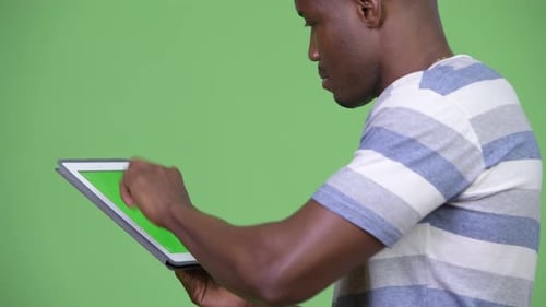Young Adult Using Tablet with Chroma Key Screen