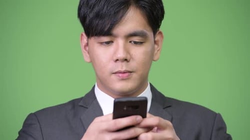Young Adult in Suit Using Smartphone