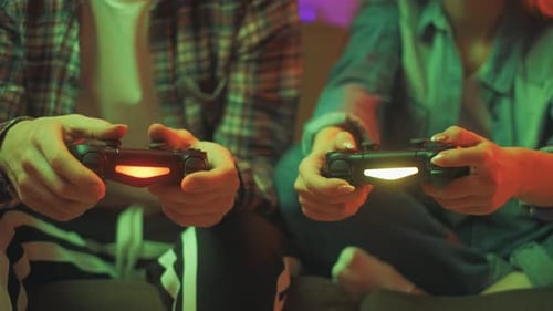 Hands of a Man and Girl Holding a Joysticks To Play Video Games on TV