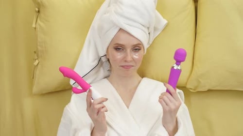 Eine aufgeregte junge Frau whlt einen Vibrator und ein Dildo-Sexspielzeug, mit dem sie Spa haben kann Eine aufgeregte junge Frau whlt einen Vibrator und ein Dildo-Sexspielzeug, mit dem sie Spa haben kann