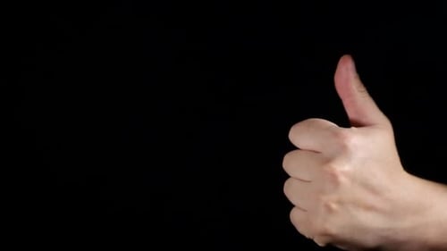Hand Giving Thumbs Up on Black Background