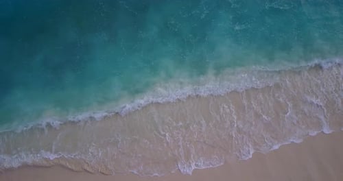 Wide overhead copy space shot of a white sand paradise beach and blue water background