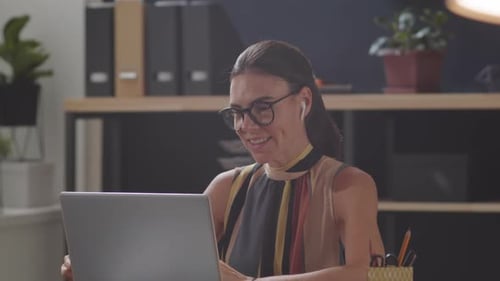 Beautiful Businesswoman Video Calling on Laptop in Office