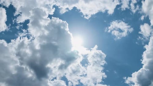 Timelapse à faible angle Soleil lumineux sur le ciel d'été bleu avec des nuages moelleux en mouvement Rayons de soleil brillants