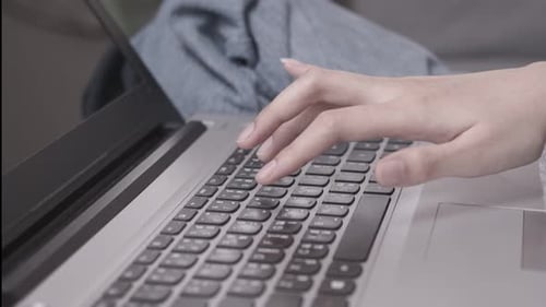 Am Morgen arbeitet asiatische berufstätige Frau mit ihrem Laptop auf dem Schreibtisch und arbeitet von zu Hause aus.