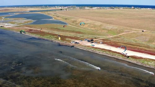 Sportsmen, people go in for kitesurfing on the sea. Top view of the kitesurfer