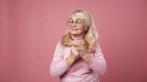 Senior Woman Dancing on Pink Background