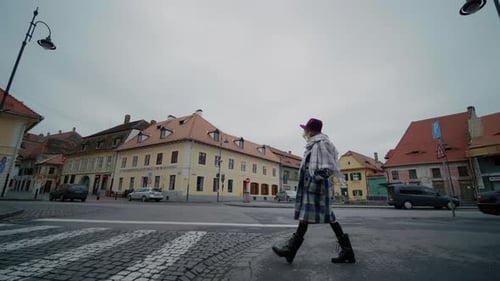 Vista lateral da mulher atravessando o pedestre em uma nova cidade.