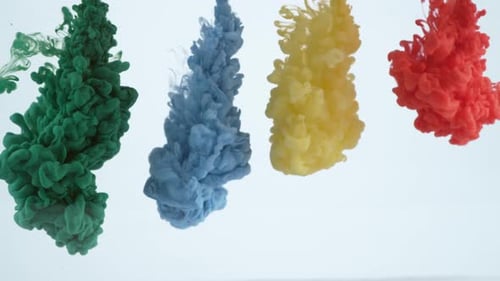 Zeitlupenaufnahme von grüner, blauer, gelber und roter Tinte, die ins Wasser fließt, aufgenommen mit Phantom Flex 4K ca