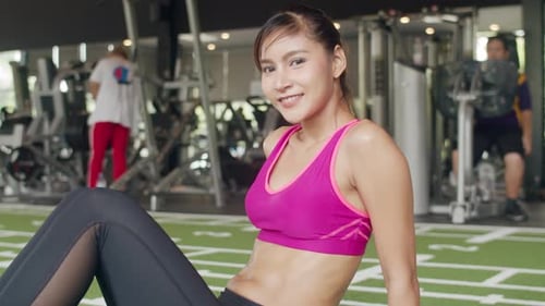 Woman Does Sit Ups at the Gym