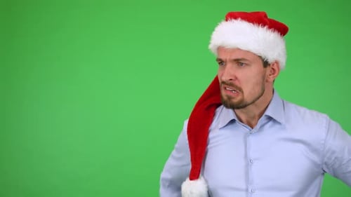A Young Handsome Man in a Christmas Hat Acts Angry - Green Screen Studio