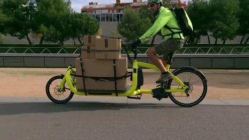 Man Rides Yellow Cargo Bike with Boxes
