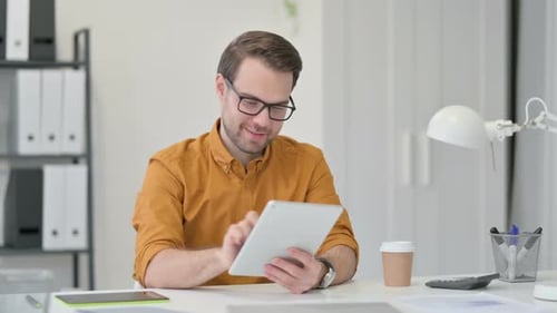 Young Adult Man Using Tablet in Office Setting