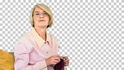 Cheerful elderly woman knitting and listening, Alpha Channel